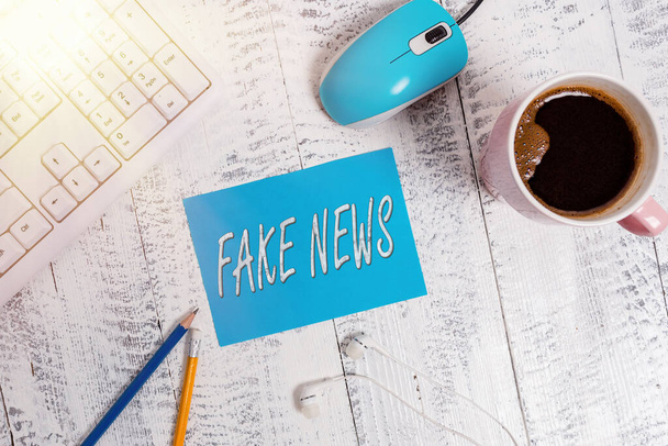 Word writing text Fake News. Business concept for false information publish under the guise of being authentic news technological devices colored reminder paper office supplies keyboard mouse. - Photo, Image