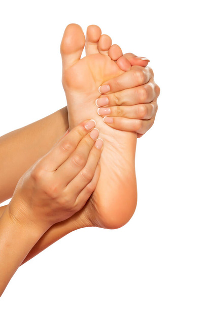 mulher massageando seu pé doloroso no fundo branco
 - Foto, Imagem