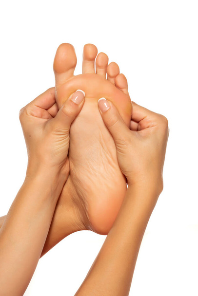 mulher massageando seu pé doloroso no fundo branco
 - Foto, Imagem