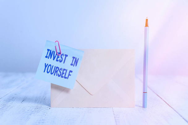 Conceptual hand writing showing Invest In Yourself. Business photo text learn new things or materials thus making your lot better Standing envelope sticky note marker old wooden vintage background. - Photo, Image