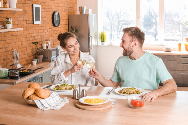 幸せな若いカップルが台所で昼食を持っている - 写真・画像