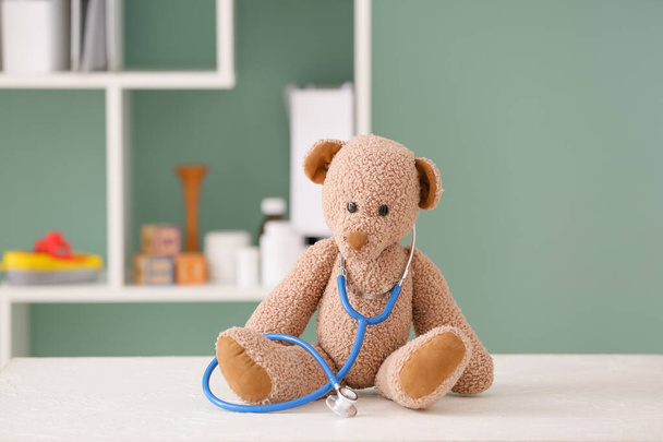 Toy and stethoscope on table in clinic - Photo, Image