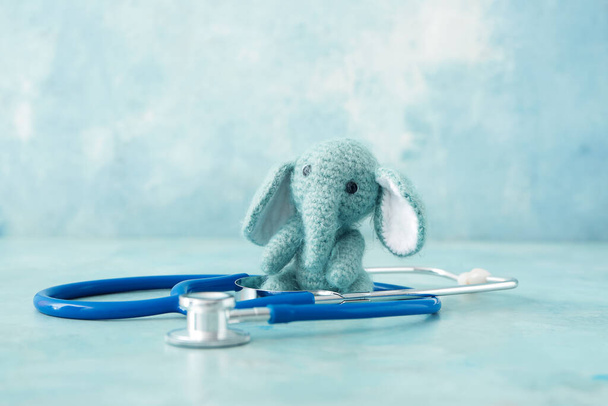 Spielzeug mit Stethoskop auf farbigem Hintergrund - Foto, Bild