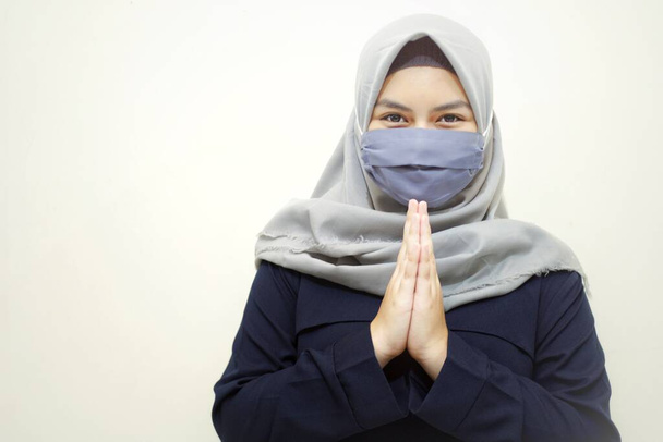 Muslimische Hidschab-Frauen mit Gesichtsmaske in Grußgeste. Muslimische Frauen in der Coronavirus-Prävention durch Mundschutz. - Foto, Bild
