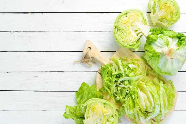 Lettuce on a white wooden background. Green healthy food. Iceberg lettuce. Top view. Free copy space. - Fotó, kép