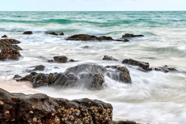 波状の海で岩が海岸近くにあり. - 写真・画像
