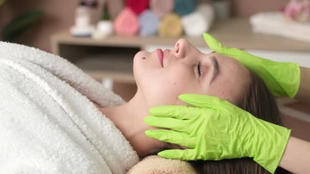 Massaggio al viso. Bella donna ottenere massaggio rilassante massaggio nel salone spa
 - Filmati, video