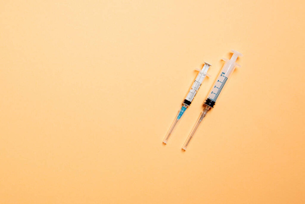 Vista superior de seringas médicas em fundo colorido com espaço de cópia. Conceito de equipamento de injeção
. - Foto, Imagem