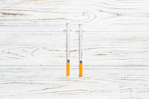 Top view of insulin syringe prepared for injection at wooden background. Diabetes concept with copy space. - Photo, Image