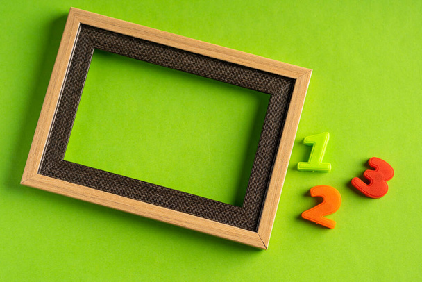 123 and empty photo frame against green background. - Photo, Image
