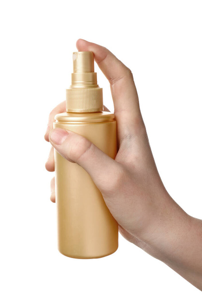 Main féminine avec spray capillaire sur fond blanc
 - Photo, image