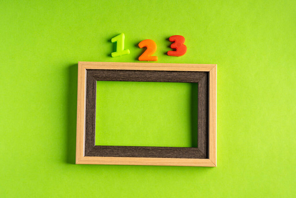 123 and empty photo frame against green background. - Photo, Image