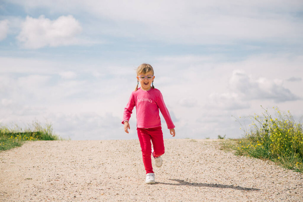 little girl with glasses running - Photo, Image