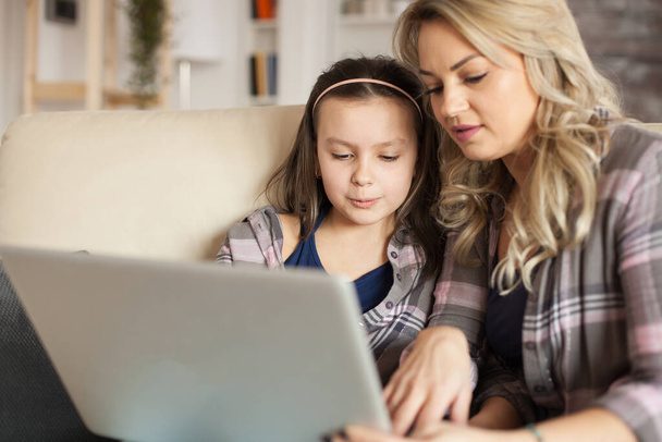 Matka pomaga małej córce pisać na klawiaturze laptopa - Zdjęcie, obraz