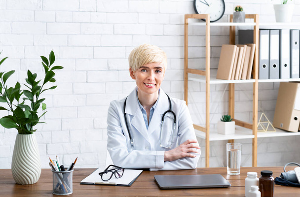 Visit to therapist in office. Smiling woman doctor sitting at table - Photo, image