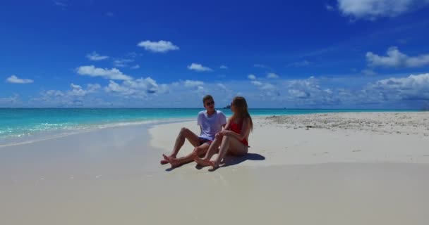 счастливая романтическая пара влюбленных, сидящая на пляже - Кадры, видео