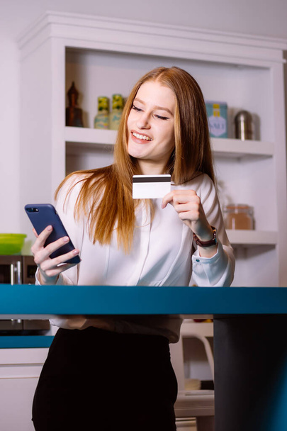 Tyylikäs nuori nainen ostaa verkossa kotoa älypuhelimellaan
 - Valokuva, kuva