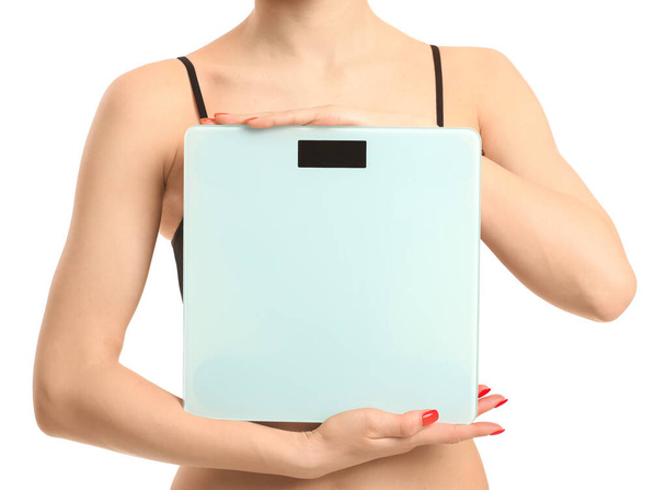 Young woman with weight scales on white background - Foto, Imagen