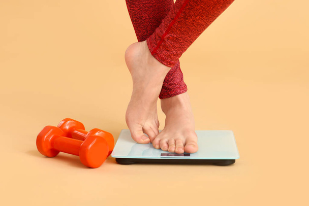 Jeune femme mesurant son poids sur fond de couleur
 - Photo, image