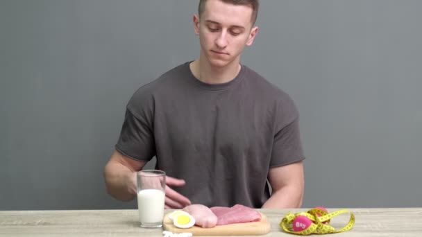 健康的な食事の概念。運動器の男はタンパク質の高い健康食品を食べる - 映像、動画