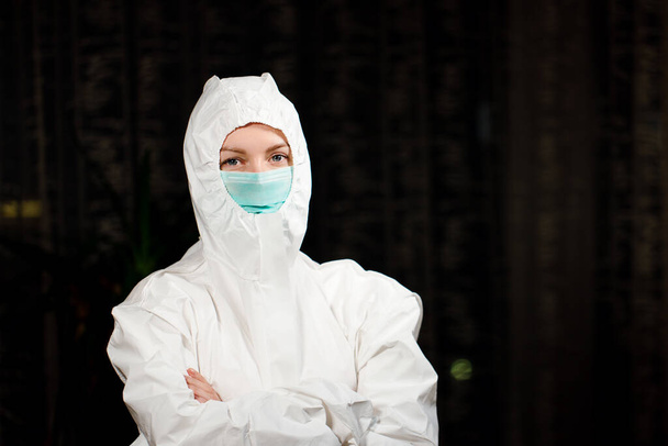 La doctora en traje médico protector y máscara quirúrgica te mira
 - Foto, imagen