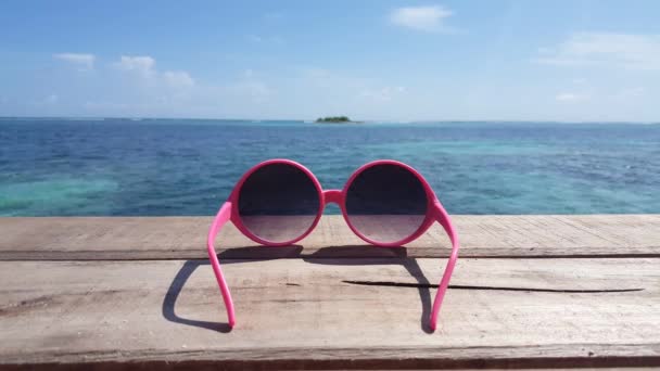 Солнечные очки на берегу моря. Летний отдых в Бора-Бора, Французская Полинезия. - Кадры, видео