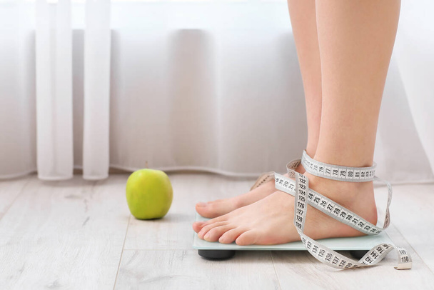 Jeune femme mesurant son poids à la maison
 - Photo, image