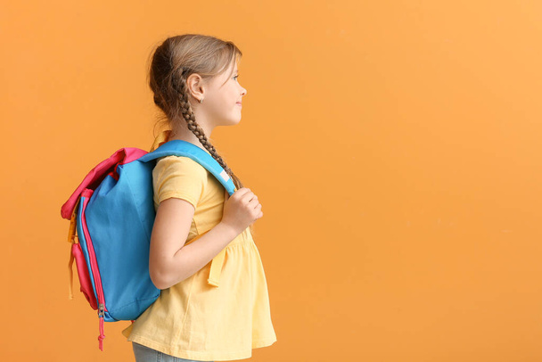 Cute little schoolgirl on color background - Foto, afbeelding