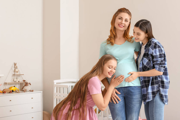 Lesbian couple and pregnant woman at home. Surrogate motherhood concept - Photo, Image