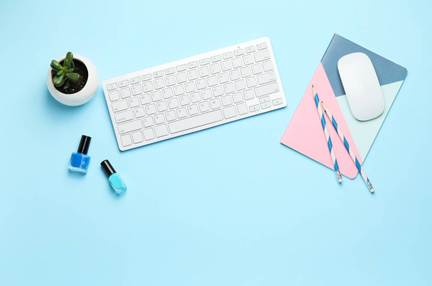 Computer keyboard with notebook and nail polish on color background - Valokuva, kuva