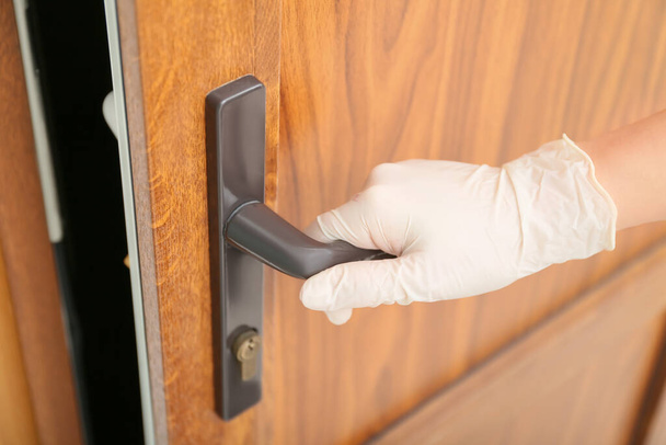 Kobieta w rękawiczkach ochronnych otwierających drzwi, zbliżenie - Zdjęcie, obraz