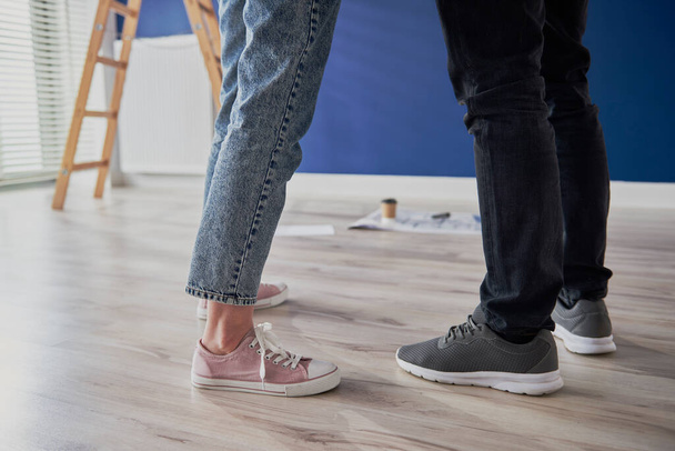 Legs of couple standing in new apartment - Foto, Bild