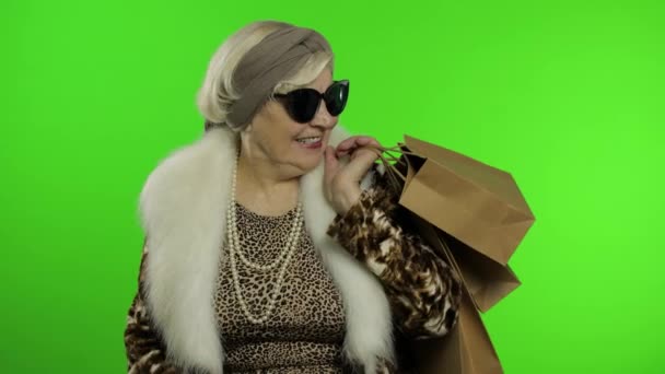 Starsza, stylowa babcia. kaukaska kobieta po udanym zakupy online - Materiał filmowy, wideo