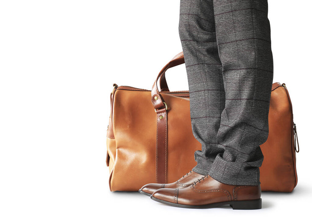 Man is holding a large brown leather bag - Photo, Image