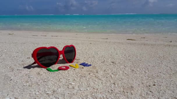 Rerd gafas de sol con letras de amor en la playa. Naturaleza idílica de Bali. - Imágenes, Vídeo