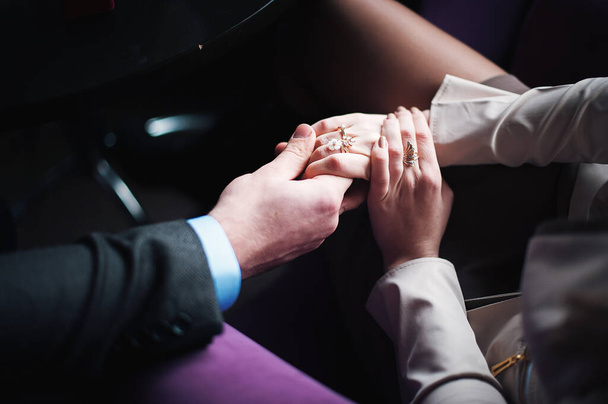 Young couple holding hands. Wedding day. Indoors - Foto, Imagen
