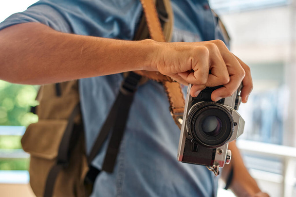 Voyageur avec chemise bleue, sac à dos, plaquette et caméra noire - Photo, image