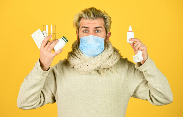 all means are good. man ready to take a pill. ill man at home. sneezing and coughing. man got flu, have runny nose. coronavirus from china. man wear respirator mask. cough cold and runny nose remedy - Fotoğraf, Görsel