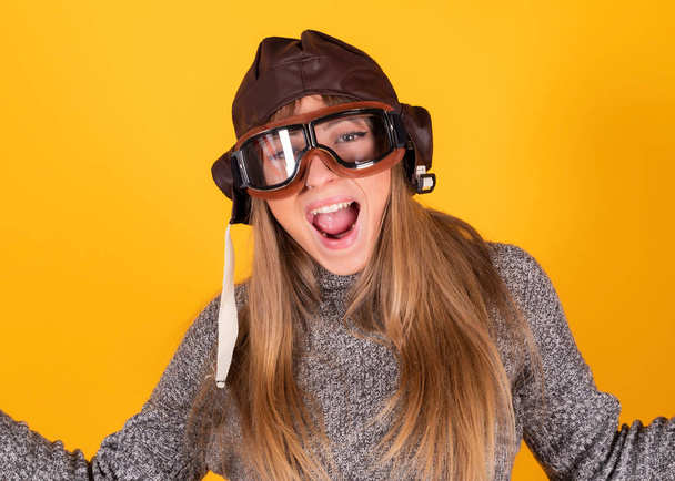 woman with clascias pilot glasses, traveling concept, on yellow background - 写真・画像