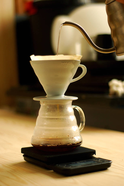 The process of brewing coffee in a funnel on the scales - 写真・画像