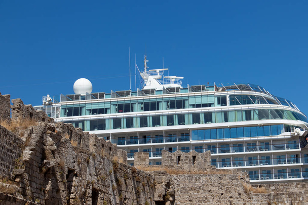A cruise ship in the port of Rhodes behind an ancient and historic wall - Photo, Image
