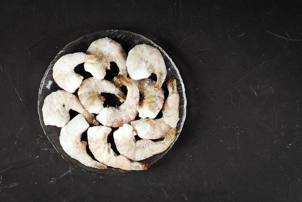 Crevettes congelées sur un tableau sombre avec un endroit pour votre texte - Photo, image
