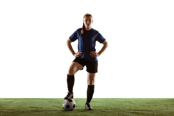 Fußballerin posiert selbstbewusst mit Ball auf weißem Hintergrund - Foto, Bild