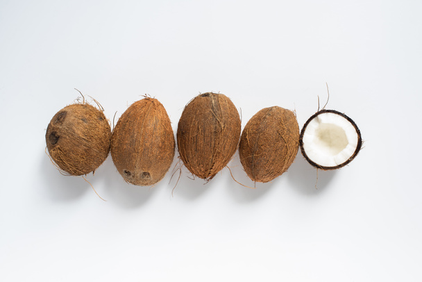 top view of fresh tasty whole coconuts and half on white background - Photo, Image