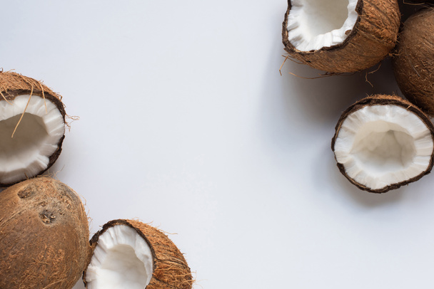 top view of fresh tasty whole coconuts and halves on white background - Foto, afbeelding