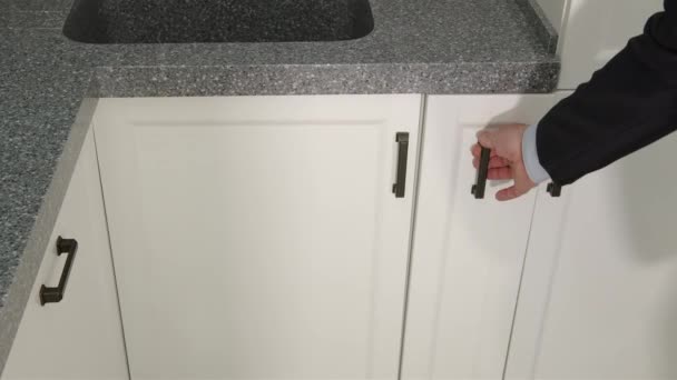 Ein Mann in der Küche öffnet eine leere Ladung, um Küchenutensilien aufzubewahren. - Filmmaterial, Video