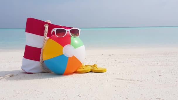 Plajda parmak arası terlik, çanta ve güneş gözlüğü olan bir top. Bali, Endonezya 'ya egzotik yaz gezisi.  - Video, Çekim
