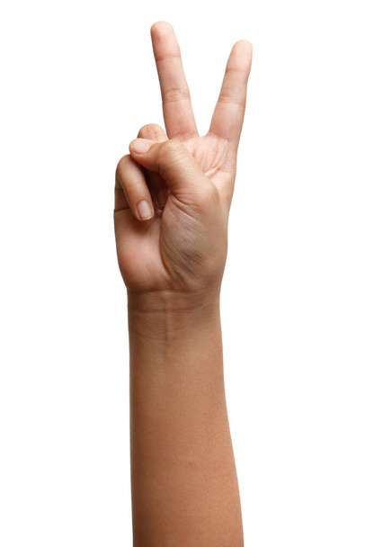 Garçon gestes de la main asiatique isolé sur le fond blanc. Signe de victoire à deux doigts. Symbole d'arme
 - Photo, image