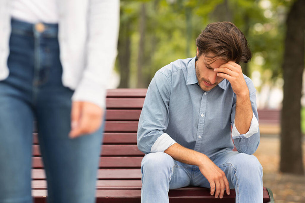 Tuntematon tyttöystävä jättää surullinen poikaystävä istuu penkillä puistossa
 - Valokuva, kuva