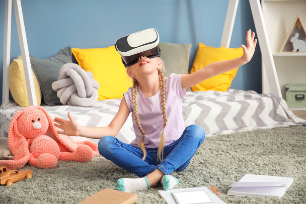 Linda niña con gafas VR estudiando en casa. Concepto de educación en línea
 - Foto, Imagen